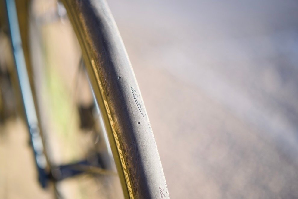 Gros plan sur un pneu gravel 700x32 slick monté sur jante, idéal pour rouler sur route ou bitume