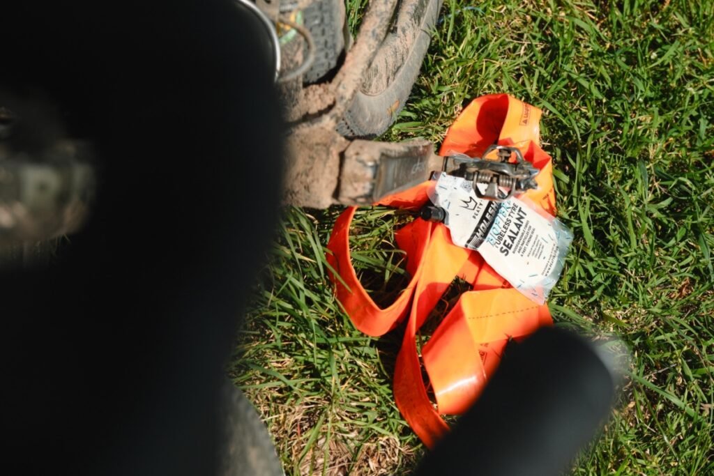 Chambre à air TPU Tubolito et dose de liquide préventif tubeless posées dans l'herbe