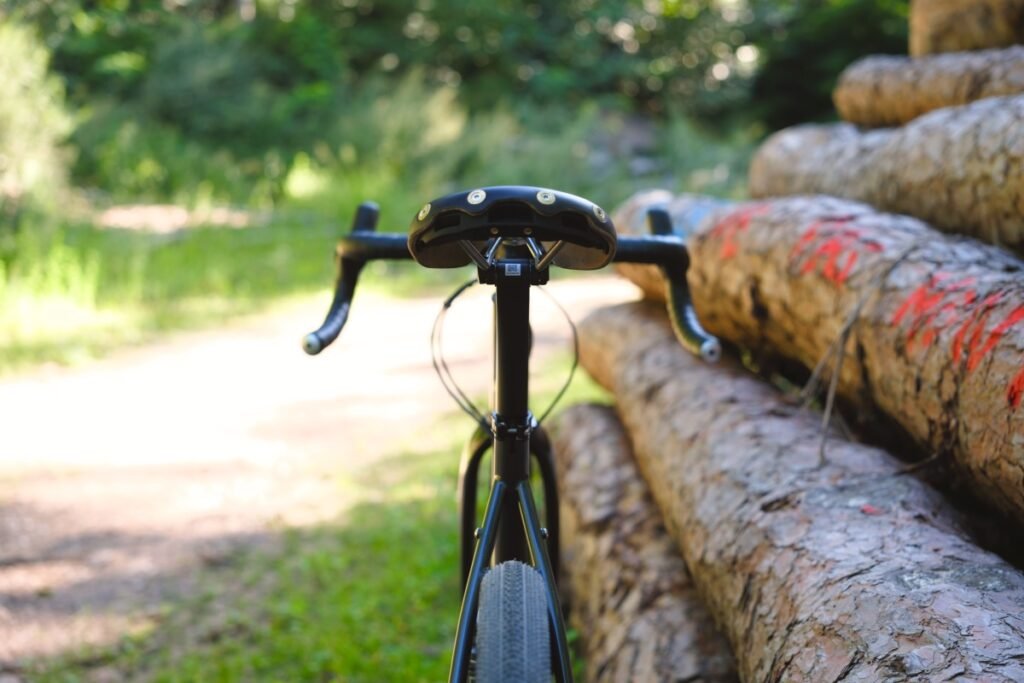 Vélo gravel avec sa tige de selle carbone sur un chemin forestier, vue de l'arrière