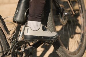 Chaussure gravel Quoc avec serrage à molette sur un vélo couvert de boue