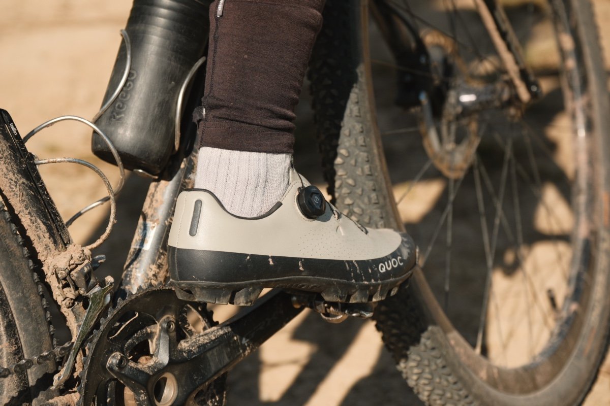 Chaussure gravel Quoc avec serrage à molette sur un vélo couvert de boue