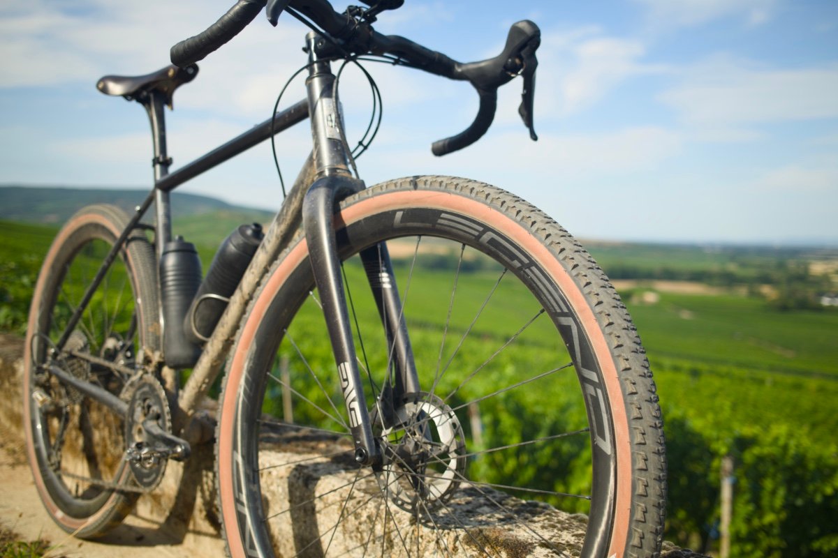 Roues carbone Legend Wheels 35H Gravel PRO 2026 montées sur un gravel à cadre acier devant un vignoble