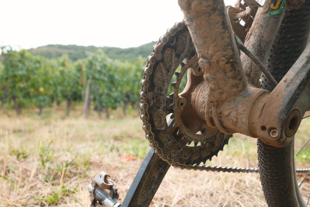 Plateau ovale et pédalier entièrement recouverts de boue séchée après une sortie sur terrain humide