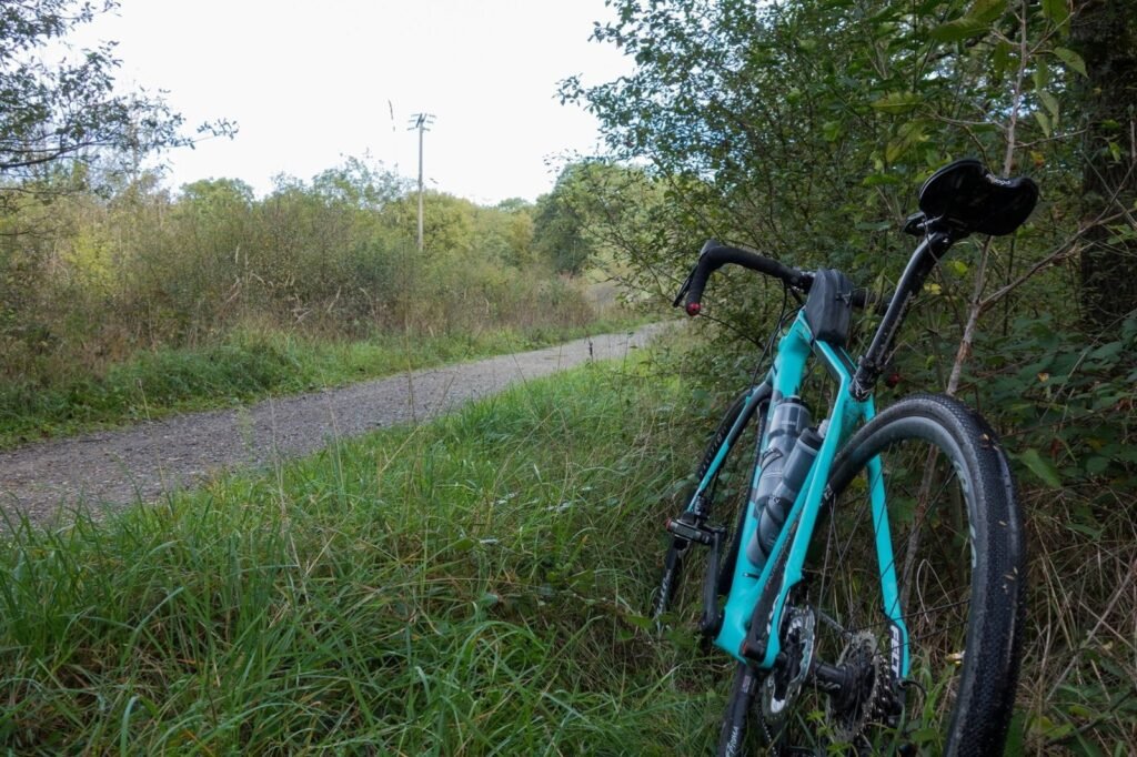 Gravel Felt VR1 en pneus 700x35 appuyé contre un poteau, devant un chemin de campagne plat et roulant en hiver