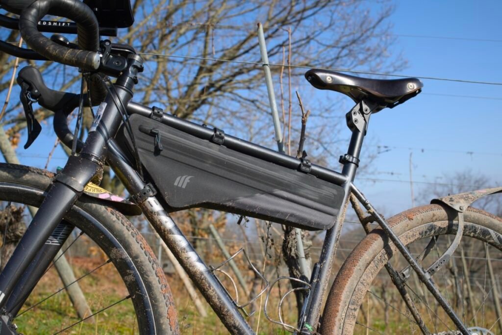 Quelle sacoche gravel pour rouler à la journée ? 7 Sacoche de cadre Tailfin occupant toute la longueur du triangle d’un gravel, avec deux porte-bidons libres en dessous