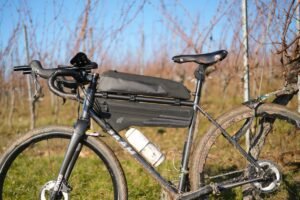 Gravel BAAM de profil dans les vignes, équipé d’une sacoche de cadre Tailfin et d’une top tube longue Tailfin